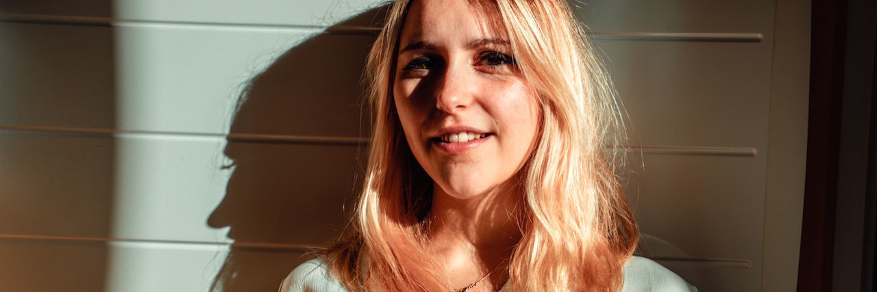 9 Common Responses to 'How Are You?' When You're Not Actually OK A woman with a bright light on her. She has blonde hair and is wearing a white blouse.