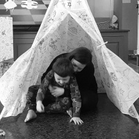 Stephanie playing with her son in an indoor tent.