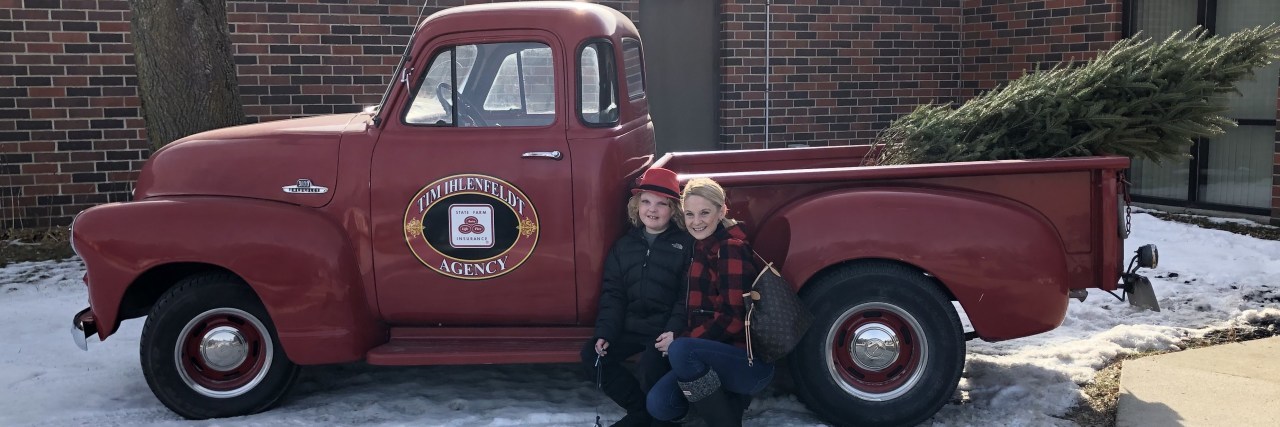 Christina with her son Urijah posing by an antique pickup truck.