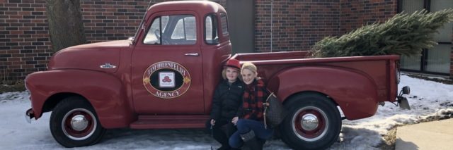 Christina with her son Urijah posing by an antique pickup truck.