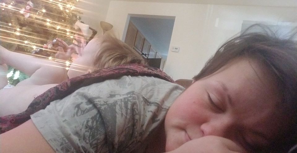 A person asleep with their child on their back