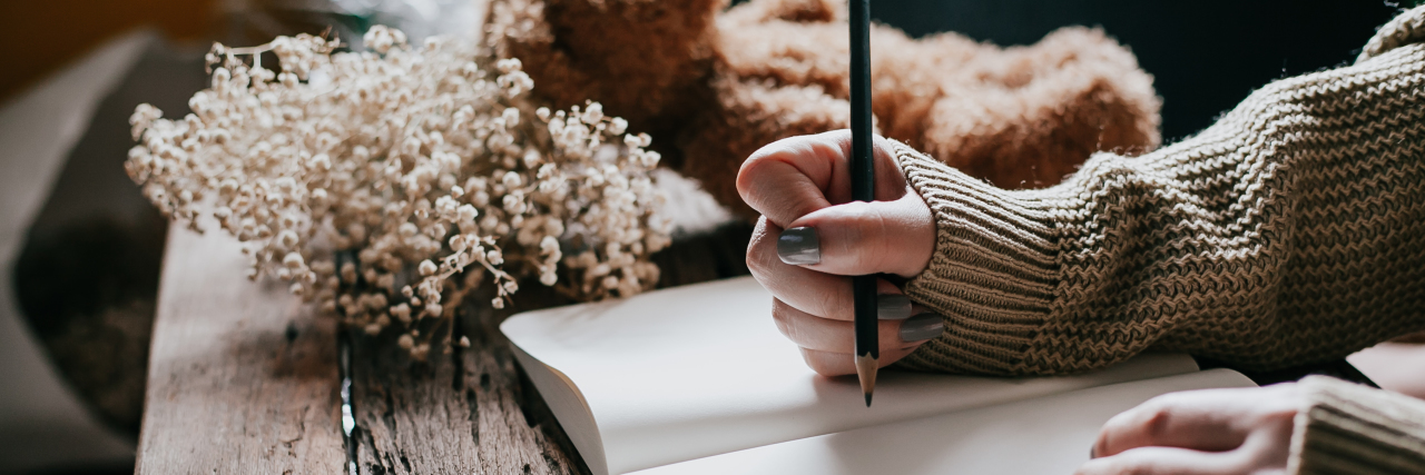 Why Grief Makes Me Who I Am close up on a woman's hand writing in a journal