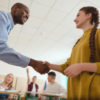 a teacher shaking her teacher's hand in a classroom