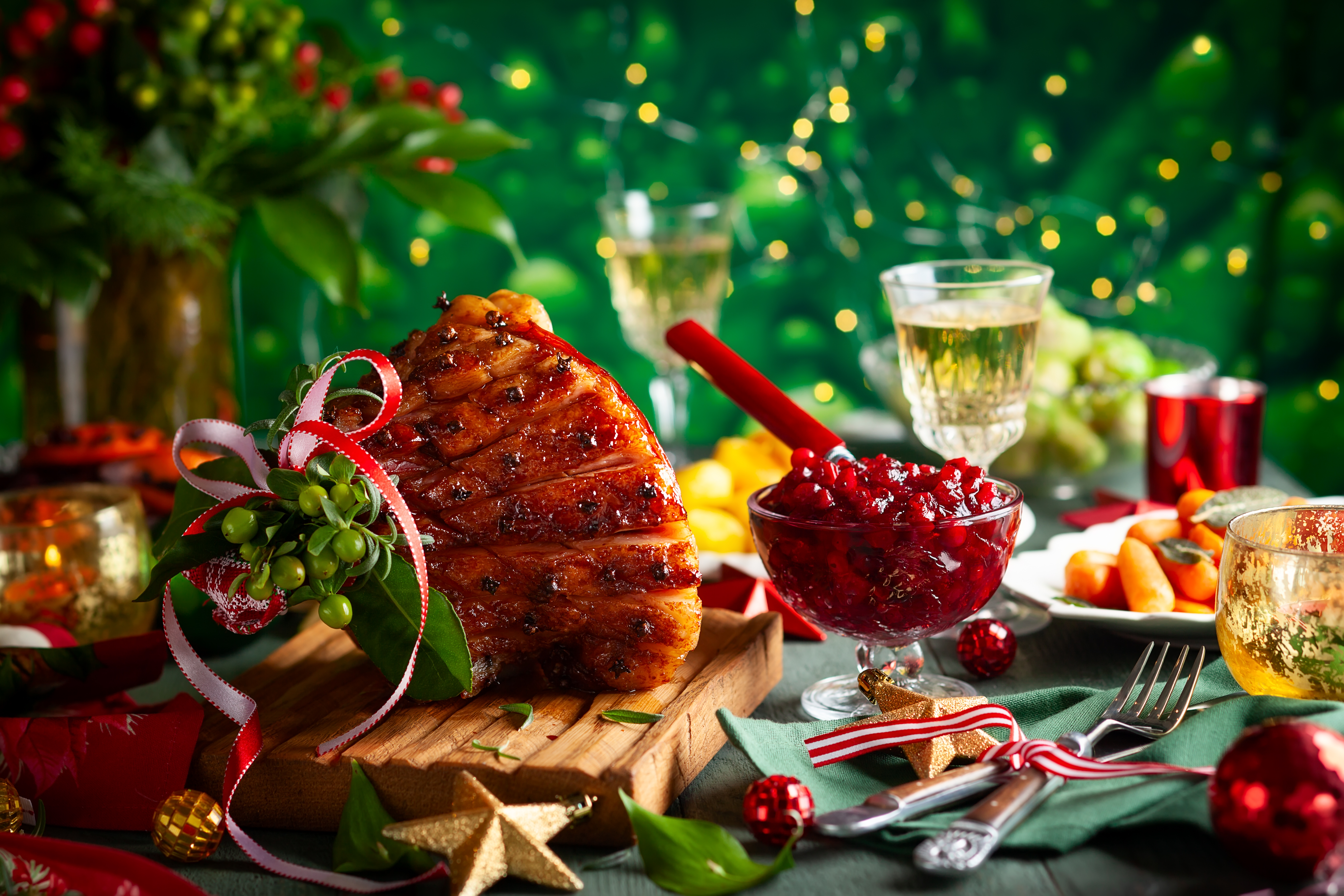 Glazed roast ham with cloves,sparkling wine and traditional vegetables dishes for Christmas dinner.