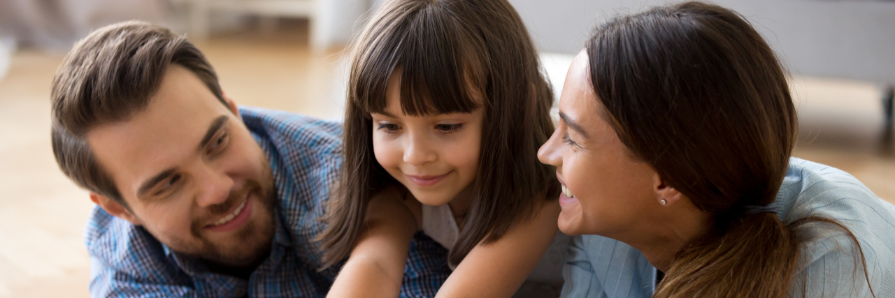 Advice for Parents of Children With Disabilities From a Disabled Adult Parents with daughter playing on the floor.