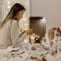 Mother tending child sick in bed during the holidays.