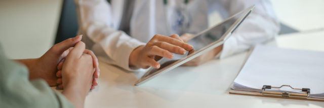 doctor showing patient information on a tablet