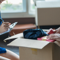Man and woman packing a moving box.