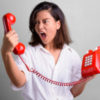 Woman yelling at the phone receiver.