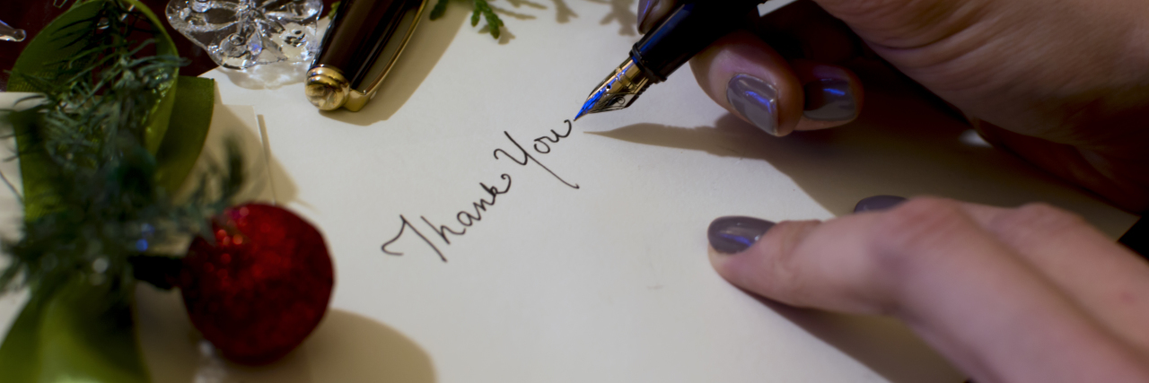 An Honest Holiday Letter From Your Loved One With Chronic Illness Woman writing Christmas letter.