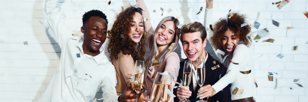 group of friends with champagne glasses dressed up celebrating New Year's