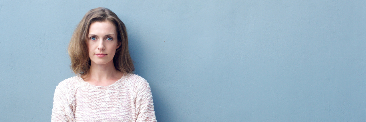 Why Alternative Therapies Won't Cure My Mental Illness serious woman with brown hair staring at camera with arms crossed