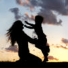 silhouette of a little boy running to his mom's arms shes smiling