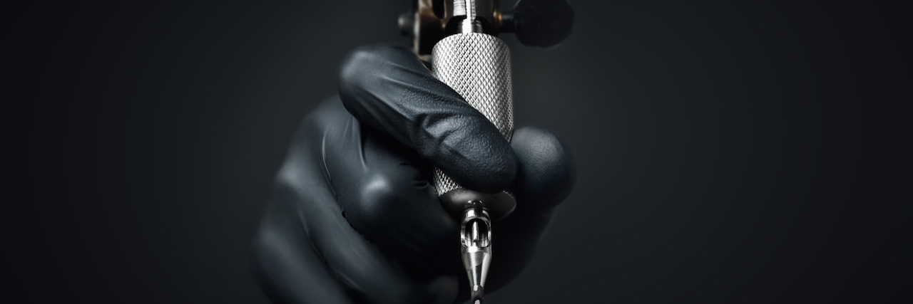 Getting a Tattoo as a Cry for Help Gloved hand holding a tattoo needle