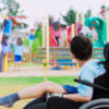 boy with a disability watches other play on playground