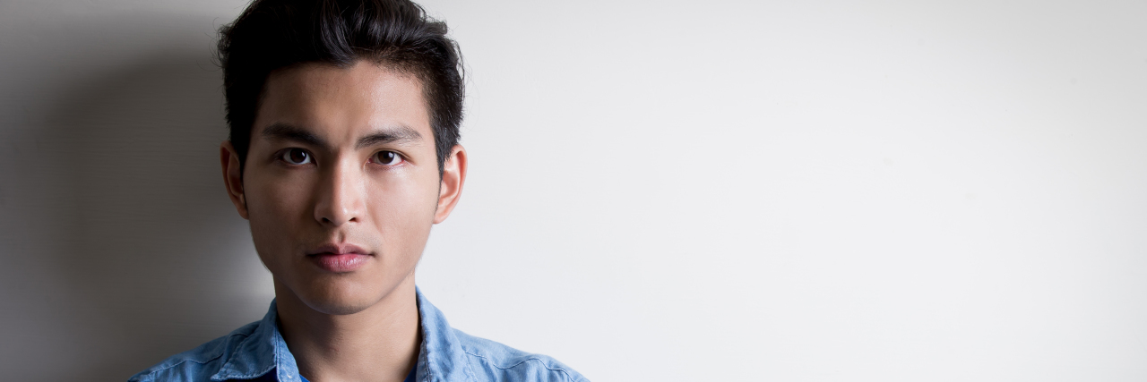 Colleges Need to Start Talking About Opioid Misuse and Abuse serious man with black hair staring at camera with arms folded