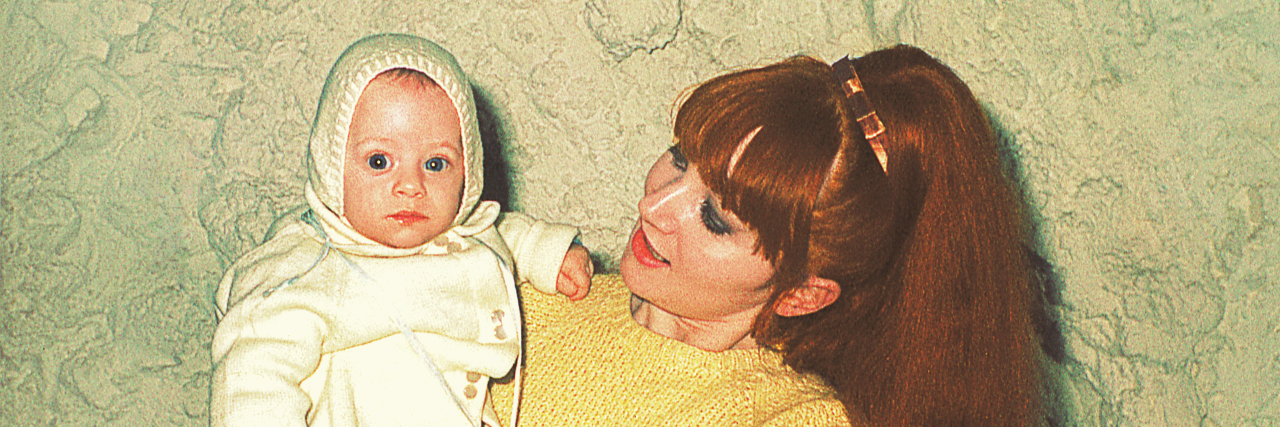 Vintage photo from the 60s of a mother holding her cute little baby.