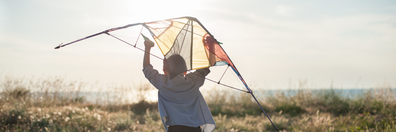 Don't Believe Negative Predictions About Your Child's Autism Diagnosis Boy launching a kite.