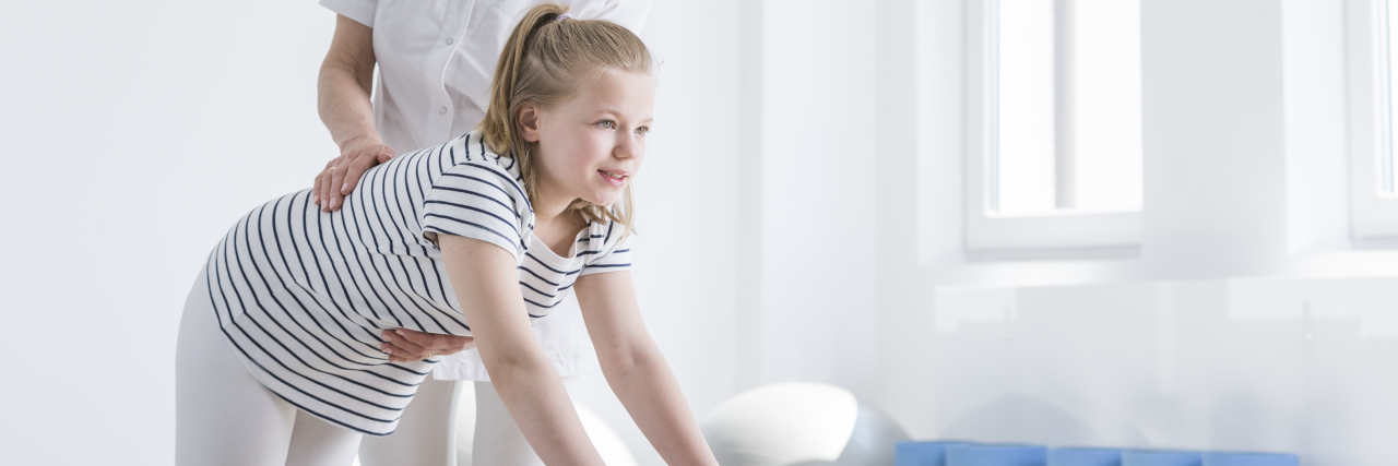 Things I Wish I'd Known About Scoliosis as a Teen Girl doing physical therapy for scoliosis.