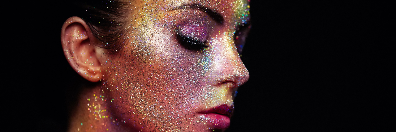 Responding to 'You’re Too Pretty to Be Disabled' Portrait of beautiful woman with sparkles on her face.