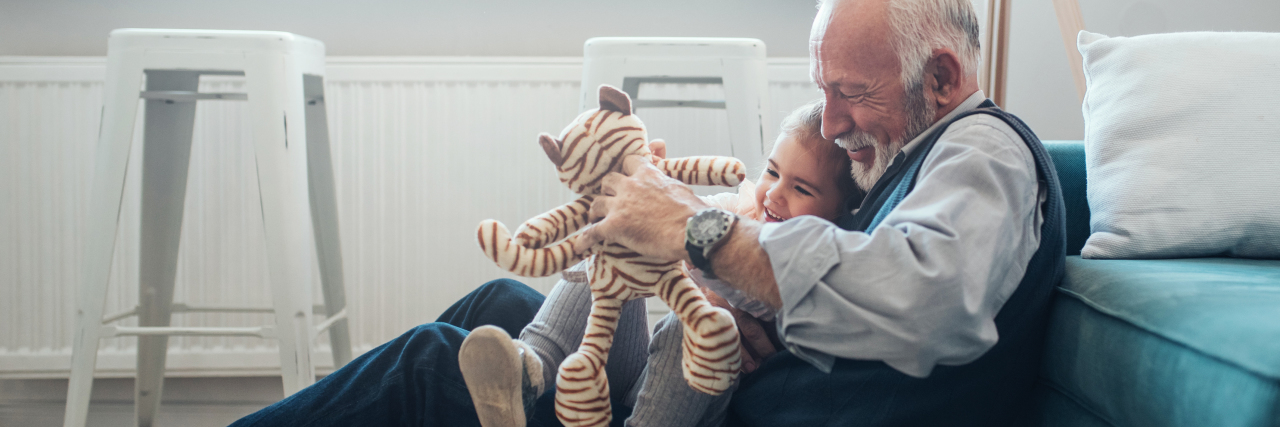 How to React When People Stare Because of Parkinson's Disease older man playing with young girl or granddaughter while sitting on floor
