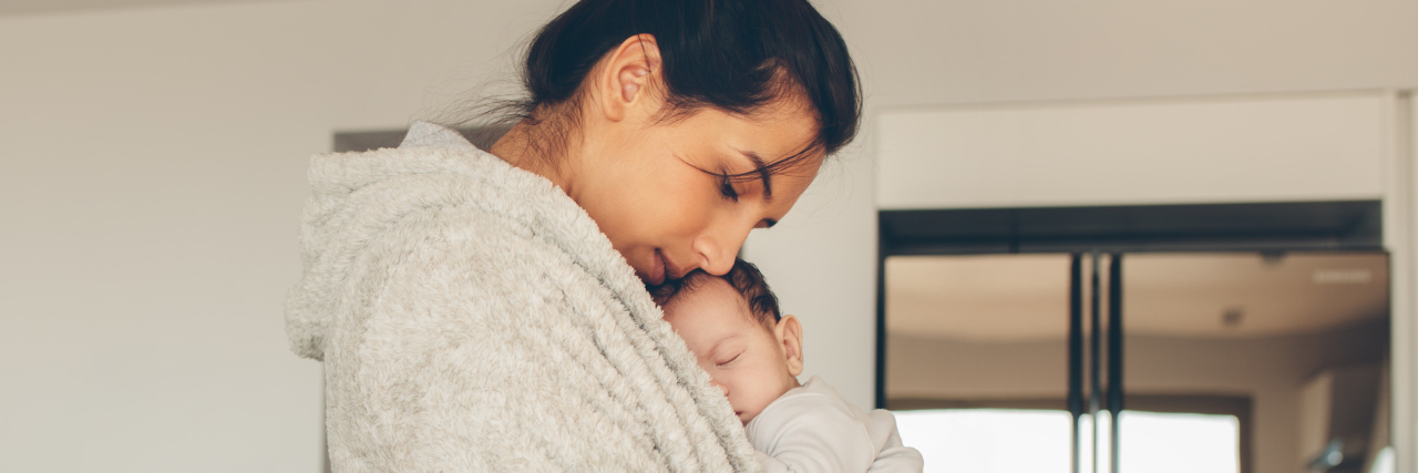 The 5 Parenting Tips I Wish I Knew as a Single Mom a woman in a bathrobe holding her son in the kitchen