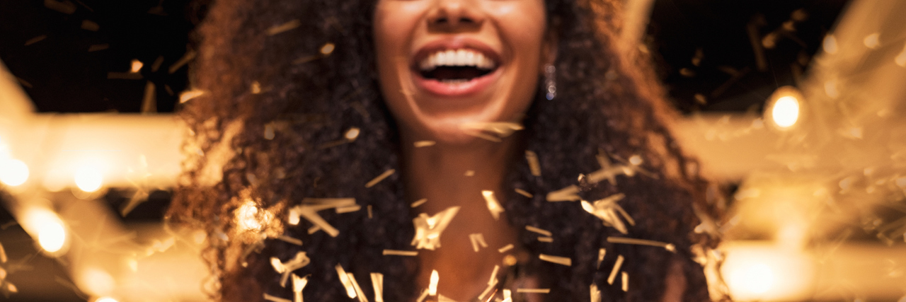 A Letter to People Who Don't Feel Accomplished This New Year's A woman holding confetti as it goes around her