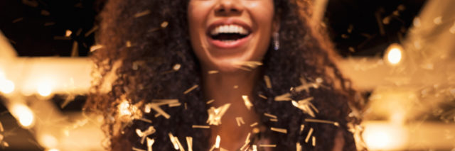 A woman holding confetti as it goes around her