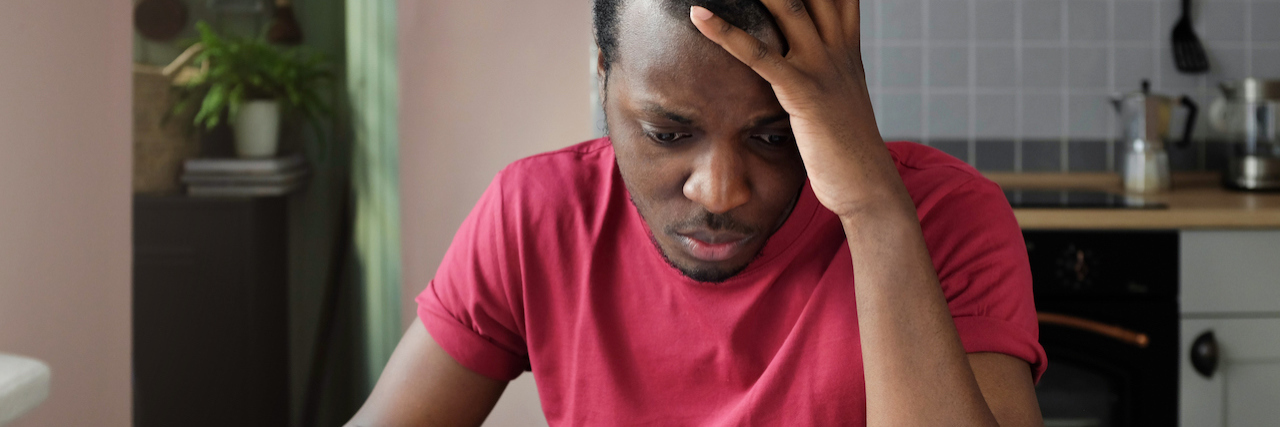 KHN: In Medical Billing, Fraudulent Charges Weirdly Pass As Legal Young anxious worrying african american man looks desperately to bills, faces problems with paying taxes, holding head with one hand