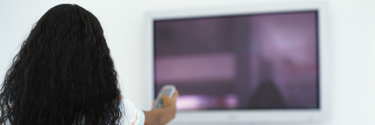 Improving Disability Representation in the Media Rear view of a girl pointing a remote at a television.