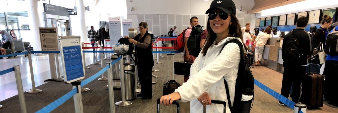 5 Tips for Celebrating the Holidays With Chronic Migraine Natalie with her suitcases at the airport.