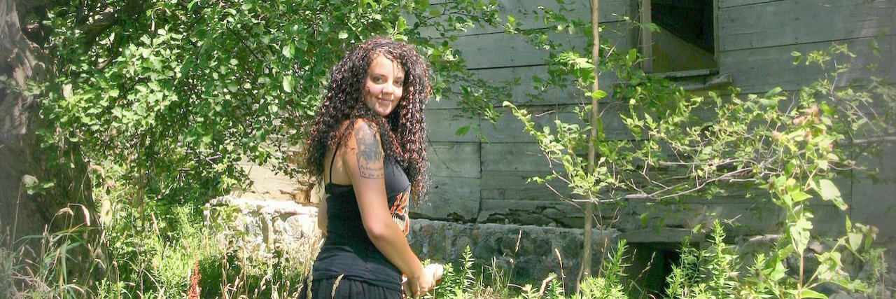 Celebrating Life in the Face of Loss: Heidi's House Woman standing outside in front of a tree and house