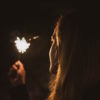 Woman holding and looking at a sparkler