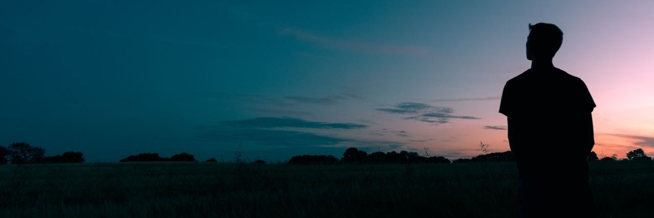 New Research Shows Connection Between Autism and Mental Illness Silhouette of a male figure looking out over a darkening sky at Sunset