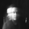 Blurred image of woman looking at and away from camera