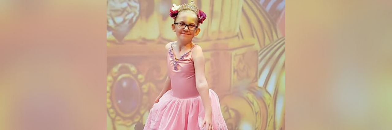 Finding an Inclusive Dance Studio for My Daughter With a Disability Callie dressed in her pink ballet outfit.