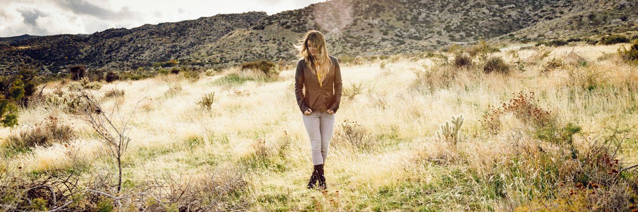 Seeking Mental Health Recovery: For Yourself, or for Others? photo of woman standing in field looking down at grass