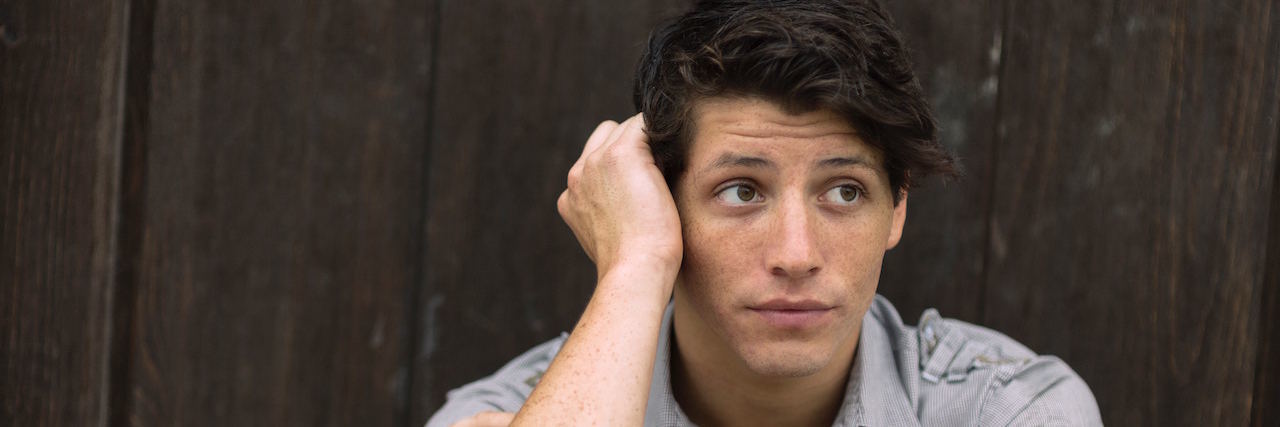 Growing Up With Bipolar Disorder Young man sitting with a thoughtful expression