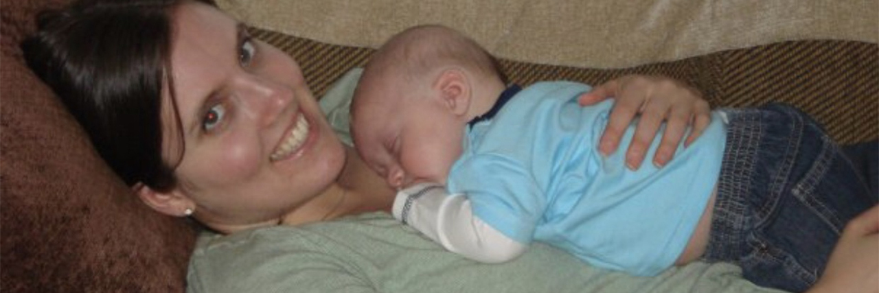 How Hyperemesis Gravidarum Caused My Antenatal Depression photo of contributor vanna winters lying back and holding baby on her chest, smiling into camera