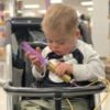 a little boy in a stroller getting a tube feeding at a store