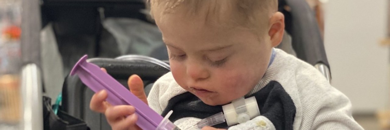 My Kid's Medical Needs Come Before Someone Else's Appetite a little boy in a stroller getting a tube feeding at a store