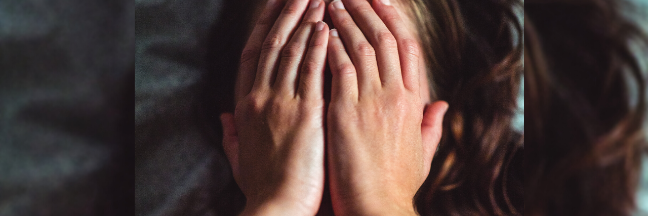 We Need to Be Honest About What Therapy Is Like close up photo of woman lying on bed with hands covering face