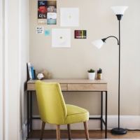 Corner office with a wooden desk, yellow padded chair and floor lamp