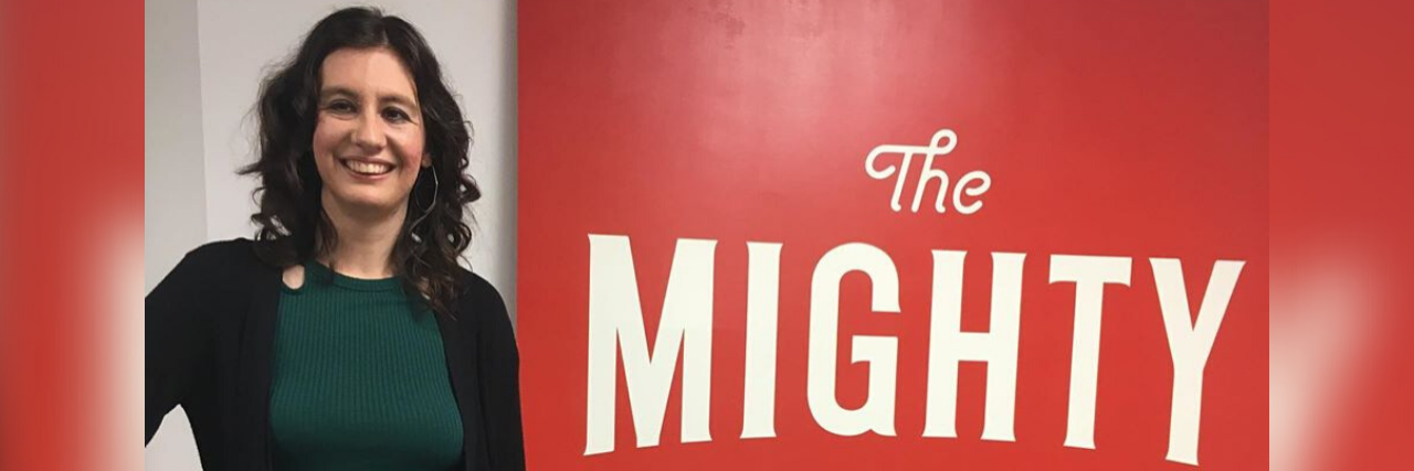 Visiting The Mighty Reminded Me Why I Share My Health Story Kelly Douglas posing with The Mighty sign at the Southern California headquarters.