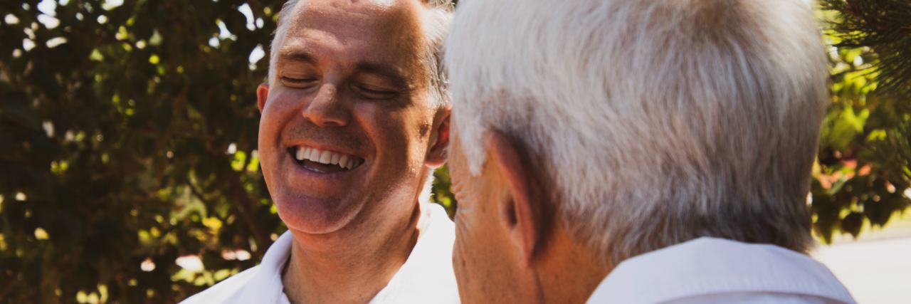 The Funny Story About My Panic Attack and Heart Palpitations photo of two mature men laughing, taken from behind one man