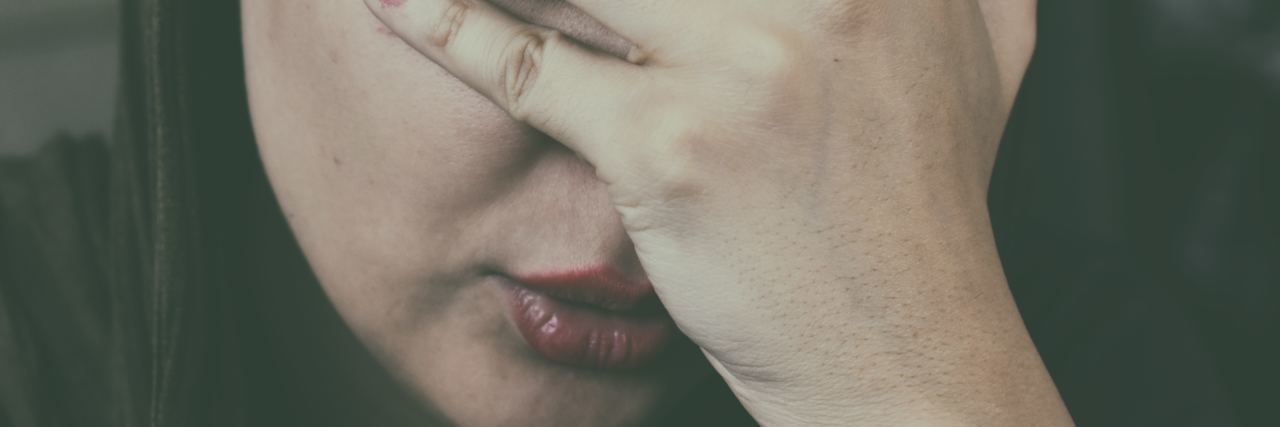 Why I Overwork Myself Despite Chronic Illness photo of tired woman resting her face in her hand