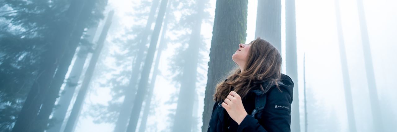 photo of woman looking up in foggy winter Sequoia National Park