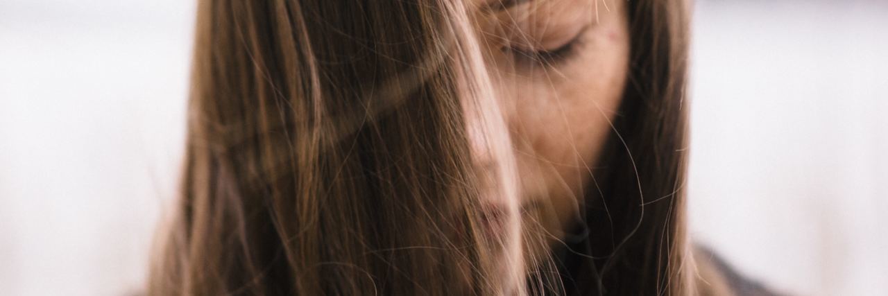 Assault by School Nurse During Trauma Crisis Shows Need for Training close up photo of young woman with eyes closed and hair partially hanging in front of face