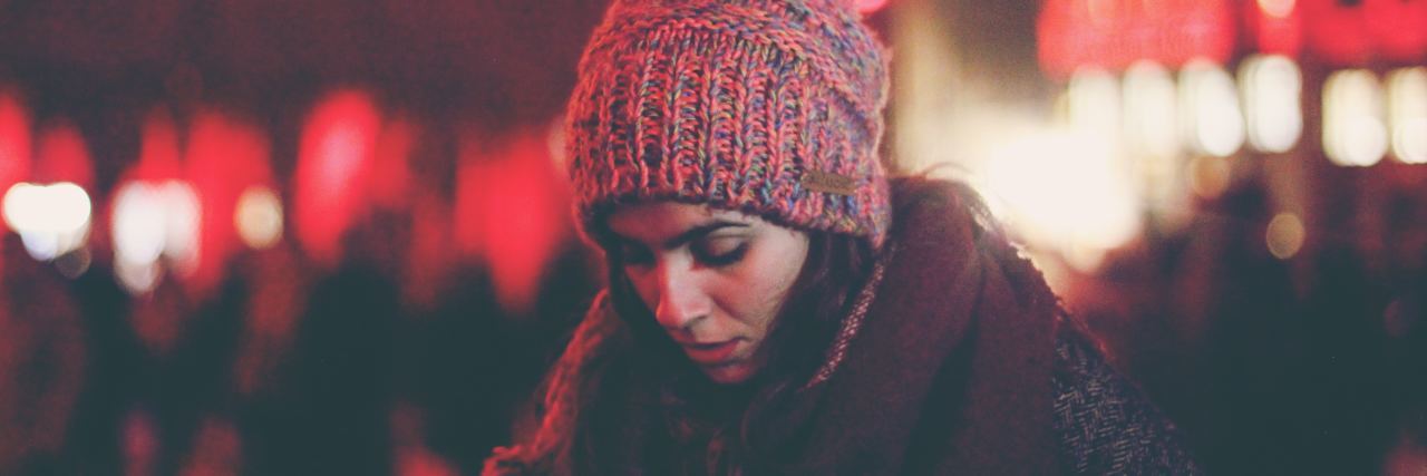 Seeing My Abuser During the Holidays Is Weakness, Not Strength woman in a winter hat looking down