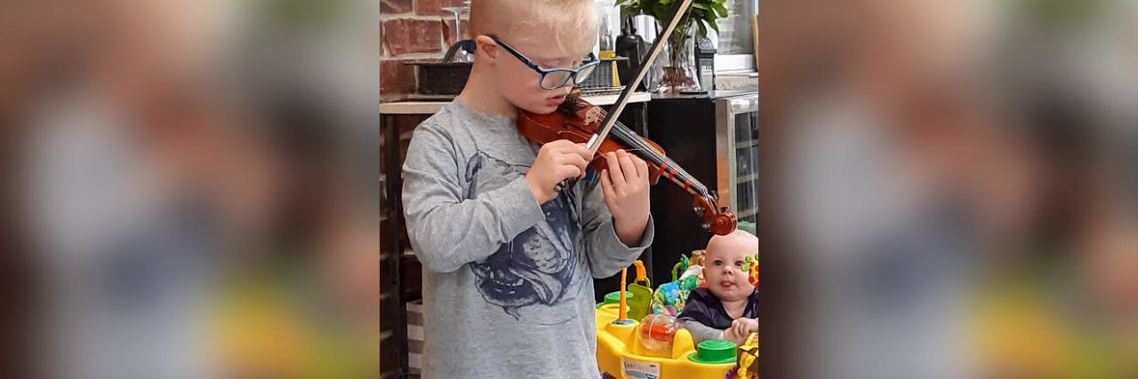 Responding to Low Expectations for Your Child With Down Syndrome Robert playing the violin for his baby brother.